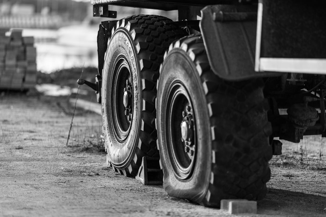 why-choose-us-02 Black and white close-up of truck tires at a construction site in Kaliningrad, Russia.